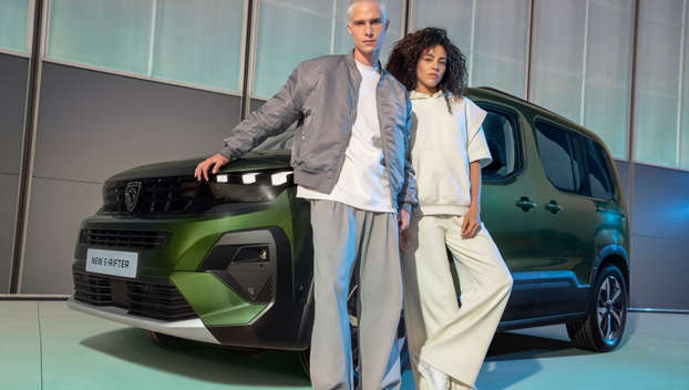 Чоловік й жінка стоять разом перед Peugeot Rifter